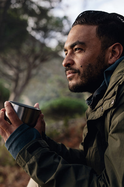 Male hiker taking rest outdoors with a cup of coffee