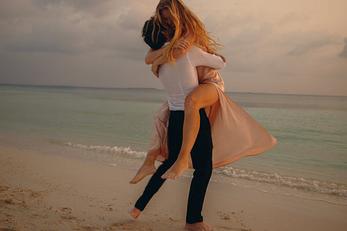 Couple enjoying a romantic honeymoon at the coast during sunset