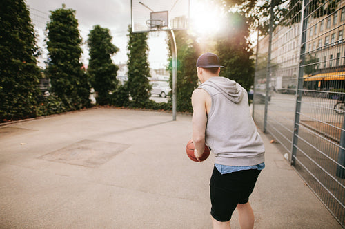 Young guy playing basketball on outdoor court