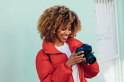 Smiling female tourist looking at her digital camera