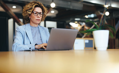 Business woman working on a laptop in a coworking office