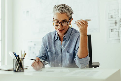 Experienced interior designer speaks to a client on a phone call, discussing details of her work