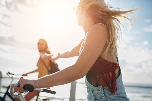 Two young female friends riding their bicycles