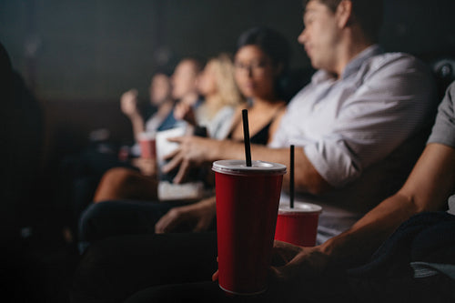 People with soft drinks in watching movie