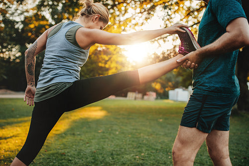 Trainer helping woman in leg stretching workout