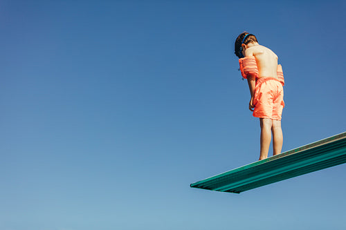 Boy learning on diving spring board