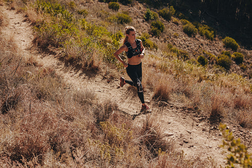 Woman running through mountain path