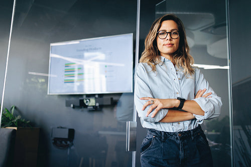 Young female professional standing in front of a meeting area in a business office