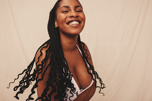 Happy young woman embracing her natural body in a studio
