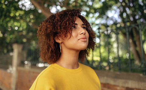 Carefree teenage girl looking up cheerfully outdoors