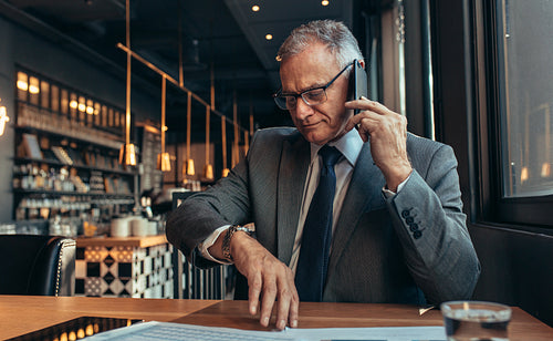 Senior businessman waiting for someone at cafe