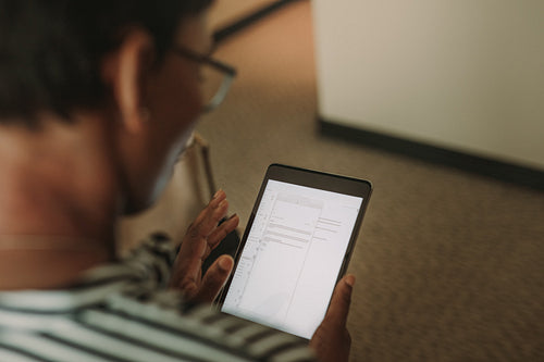 Woman in hotel room using digital tablet