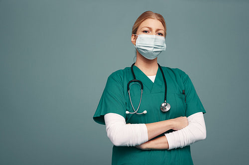 Frontline doctor wearing a mask and green scrubs