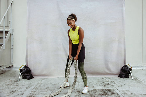 African woman doing battle rope workout