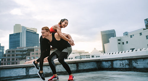 Fitness couple having fun while training on rooftop