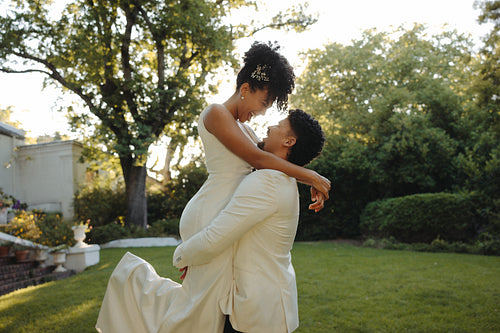 Couple embracing outdoors during their wedding day surrounded by greenery