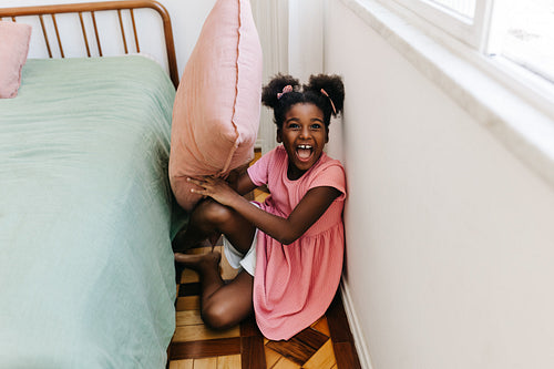 Excited young girl getting ready for a fun pillow fight