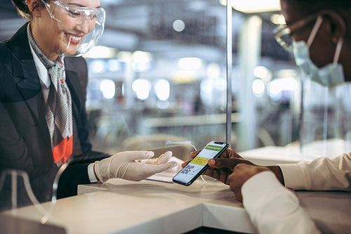Ground staff checking vaccine passport of traveler in pandemic