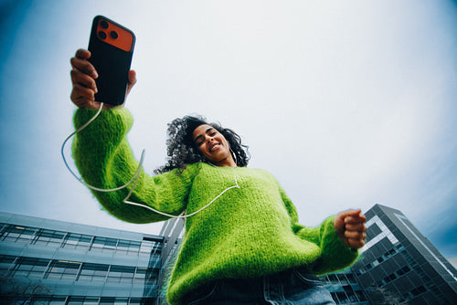 Her woman portrait captures a casual city moment with a smartphone outdoors