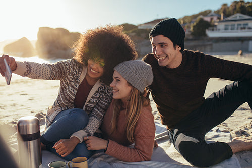 Group of friends taking selfie at beach party