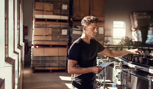 Young man working at brewery plant