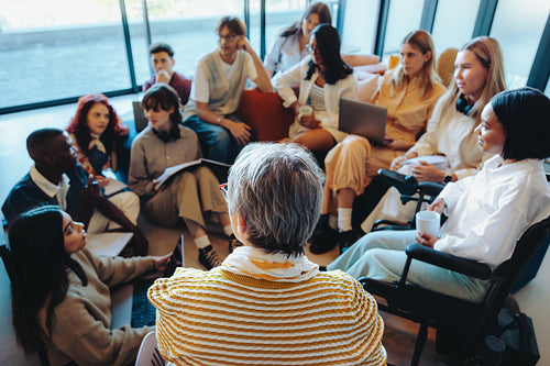 Casual classroom setting with a diverse group of students and their teacher engaged in an interactive learning session.
