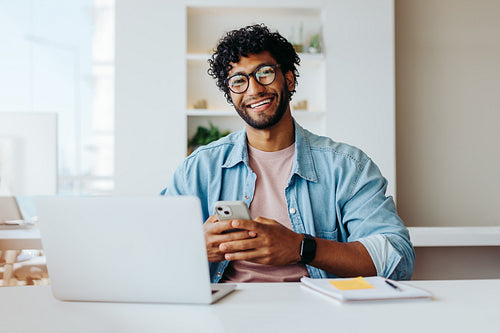 Smiling young entrepreneur at modern office workspace