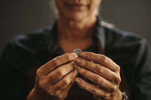 Jewelry maker hands inspecting a silver ring