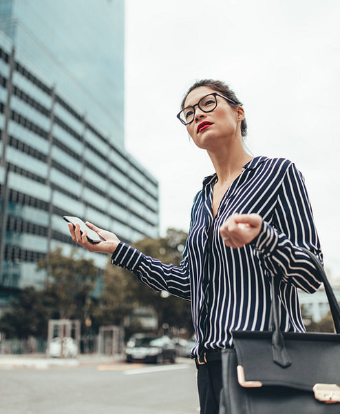 Businesswoman waiting for taxi on the city street