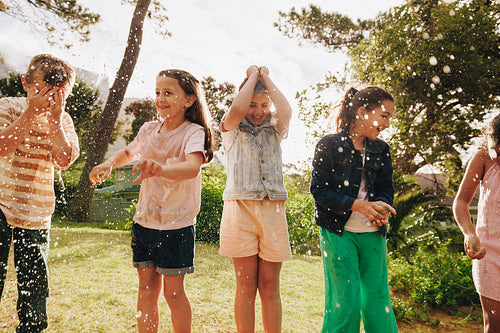 Group of children enjoying playtime with water in a sunny park