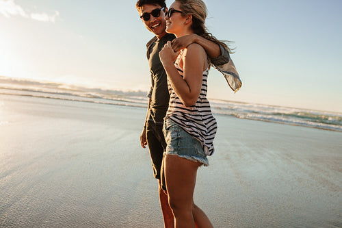 Romantic young couple strolling on the beach