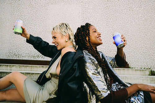 Cheers to friendship, women celebrating with drinks on the steps