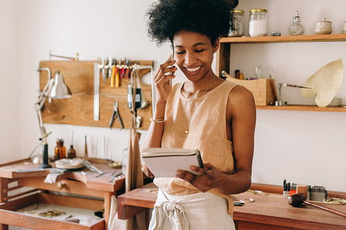 Jewelry designing businesswoman talking on phone