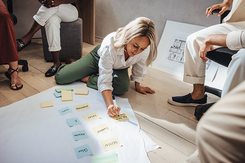 Female architect sharing ideas during team brainstorming session at creative studio.