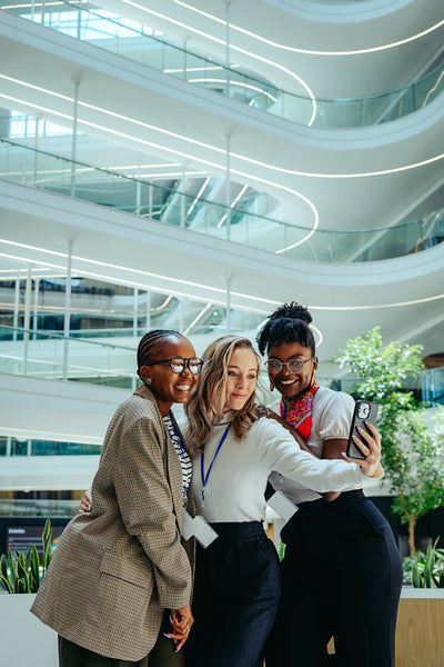 Work friends taking a joyful selfie in corporate environment