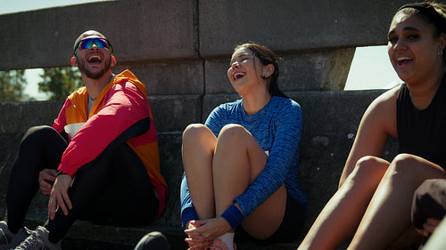 Young friends laughing and resting after a run