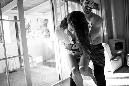 Lovers playing cheerfully in their hotel room