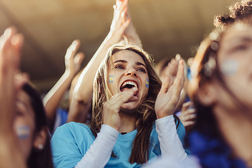 Group of Argentinian soccer fans cheering in stands
