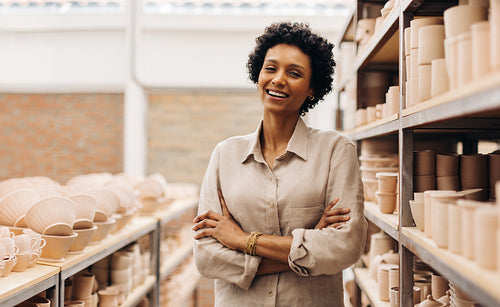 Successful female ceramist smiling at the camera happily