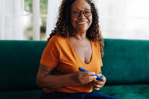 Mature woman using a smart insulin pen to control her blood sugar