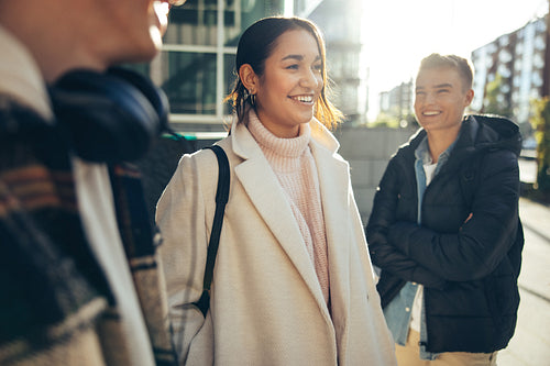 Smiling girl standing in college campus with friends