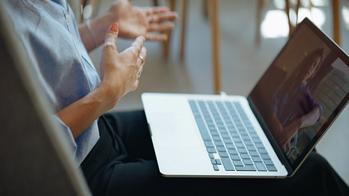 Woman speaks on a laptop video call in a candid remote workspace scene