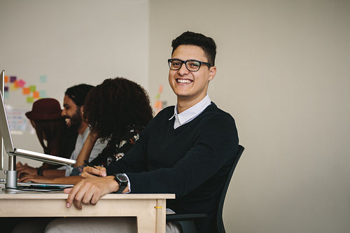 Businessman in eyeglasses sitting at his desk in office
