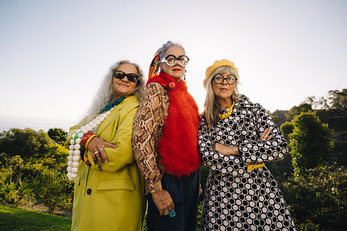 Three senior women wearing colourful clothing in a park