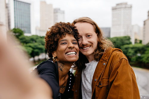 Loving couple taking a fun selfie in the city during their date