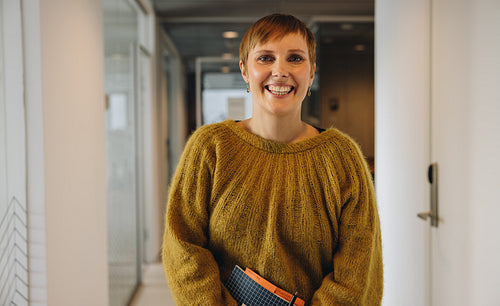 Positive businesswoman at office corridor