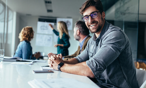 Smiling designer sitting in conference room