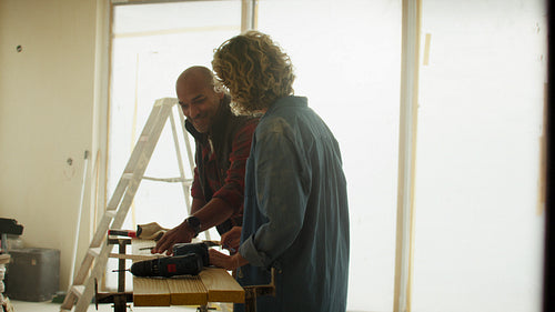 DIY dream team: Middle-aged couple discussing wood and drill placement