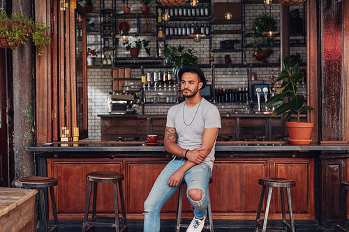 Upset young man sitting alone at a cafe counter