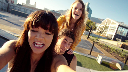 Playful skaters taking a selfie video in a skate park